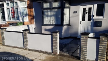 Blue perfurated brick wall with black coping and caps and grey rendering