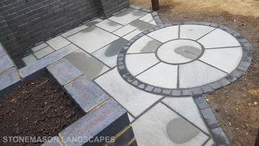 Blue Perforated Brick Wall Planter With Grey Sandstone Circle & Patio Paving & Wooden Pergola