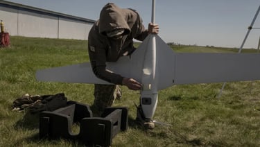 a man in a hoodie is holding a remote control plane