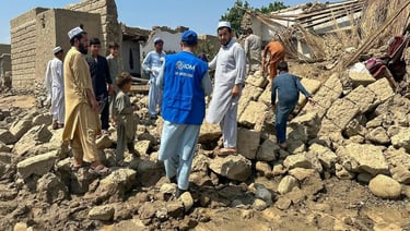 a group of people standing around a pile of rubble