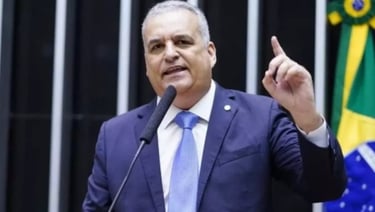 Alfredo Gaspar gesticulando em um microfone, com um terno azul.