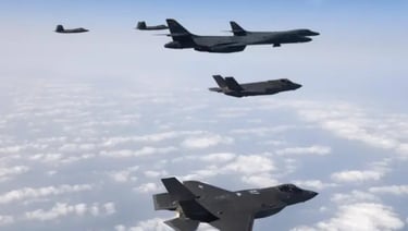 a group of four military jets flying in the sky