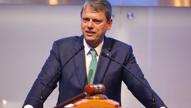 a man in a suit and tie is speaking into a microphone