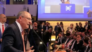 a man in a suit and tie is speaking into a microphone