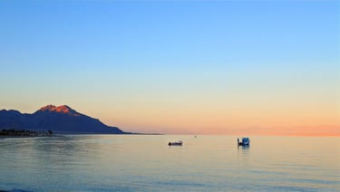 Sunset over the quiet Red Sea with Saudi Arabian mountains and boats viewed from Bedouin Star Sinai