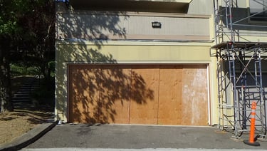 Garage opening boarded up with plywood. 