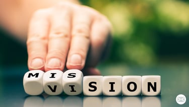 a person holding dices which together are spelling the word mission and vision