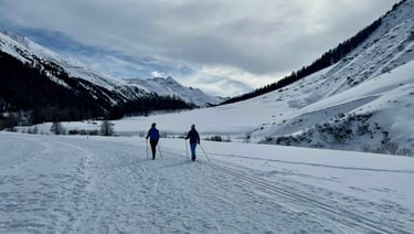 two people cross country skiing in the mountains
