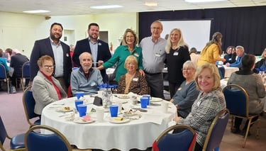 Smiling neighbors gathered around a table at a fundraising event