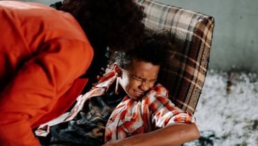 a woman sitting on a chair with a man in a red shirt