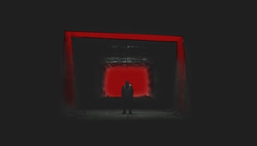a person standing in a dark room with a red light