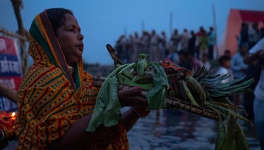 A woman in a colorful dress holding a basket of vegetables during Chhath festival