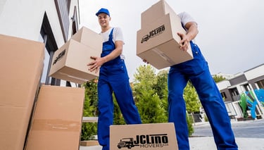 dos trabajadores de mudanza cargando cajas