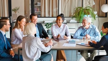 En grupp av chefer har en gruppcoaching runt ett bord.