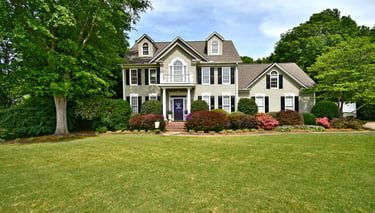 Real Estate photography of home with a manicured green lawn and professional landscaping.