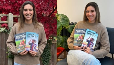 two women holding up their books and smiling