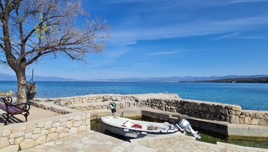 Kleiner Anlegeplatz mit Boot an der Küste von Malinska