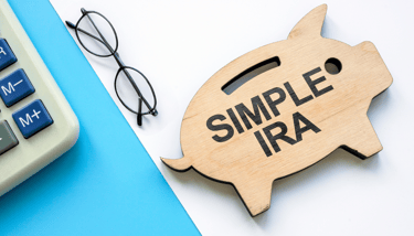 piggy bank a calculator and glasses for a simple ira