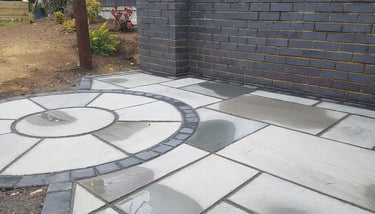 Grey sandstone circle paving slabs with charcoal edging
