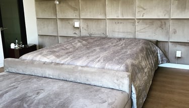 Upholstered bed with velvet wall panels in a modern bedroom by Solo Home Decor.