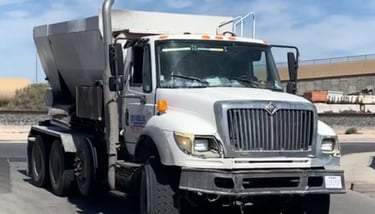 a dump truck with a cement mixer in the back ground