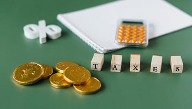 gold coins, calculator and word taxes show gold ira taxes and learning potential tax benefits