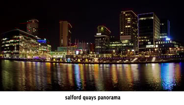 media city salford quays manchester after dark, with stunning light reflected in the water