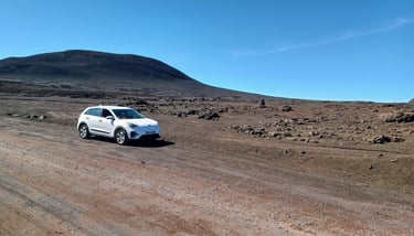a white suv driving down a dirt road