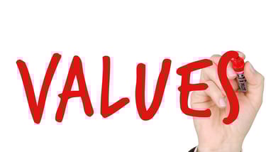 hand writing the word "values" with a marker symbolizing augusta precious metals blog post about their values