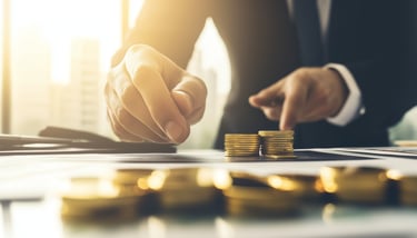 investment manager with gold coins and investing papers
