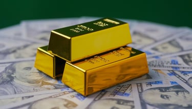gold bars in pyramid on top of 100 dollar bills
