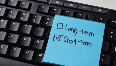 post it note with short term box checked and a keyboard