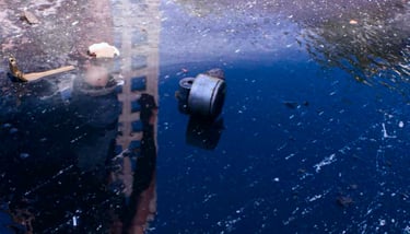 a fire hydrant sitting in the middle of a puddle