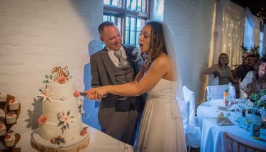 Wedding couple cutting their cake in Tudor Barn Eltham