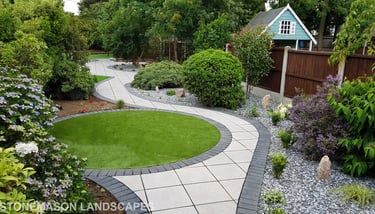Patio with custom stone circle with aggregates and paving weaving through adventurous garden design