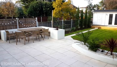 Modern chic raised porcelain patio with white rendered walls and planters