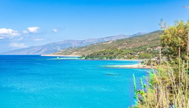 a view of a beach of Ikaria with a blue sky and a few clouds