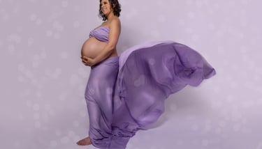 a pregnant woman in a purple dress with a flowing purple dress