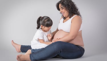 a pregnant woman sitting on the floor with her belly in her belly
