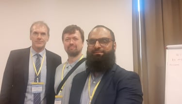 three men standing in front of a white board