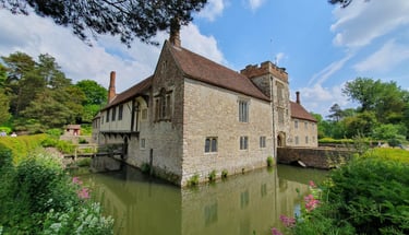 View of the house at Ightham Mote, surrounded by water.