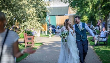 A happy bride and groom walking together in Abbey Gardens Bury St Edmunds.