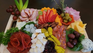 Gourmet cheese and charcuterie grazing board featuring fresh herb and strawberry garnishes for events in Aurora.