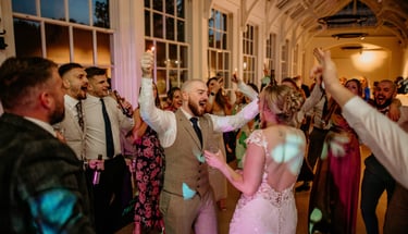 a bride and grooms dancing at a wedding party