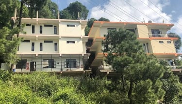 The exterior of the multi-story Mehar Rehabilitation Center building nestled in the green trees.