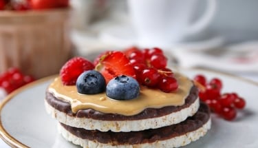 Chocolate rice cakes topped with peanut butter, fresh blueberries, strawberries, and red currants.