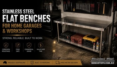 Freestanding flat top stainless steel workbench inside a residential garage.