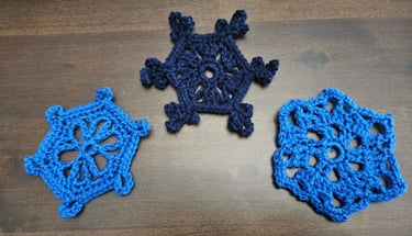 blue crochet snowflakes on a wooden table