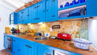 a kitchen with blue cabinets and a red refrigerator