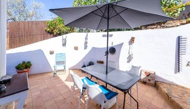 a patio with a table and chairs and umbrella